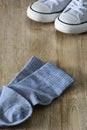 White color canvas shoes and gray socks isolated on wooden background Royalty Free Stock Photo