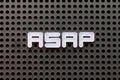 White letter in word ASAP (Abbreviation of as soon as possible) on black pegboard background