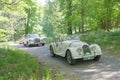 White color Morgan 4 classic car from 1958 driving on a country road