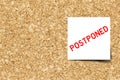 White color note with word postponed on cork board background with copy space Vector Royalty Free Stock Photo