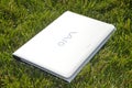 White color Sony Vaio Laptop, isolated on green grass background