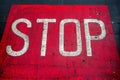 White color stop sign on a red asphalt surface. Warning information for pedestrians Royalty Free Stock Photo