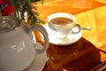 White color of Teapot and a cup of hot tea on wooden table and bright light from sun. Traditional english tea in afternoon. Royalty Free Stock Photo