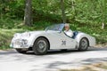 White color Triumph Sport TR3A classic car from 1960 driving on a country road