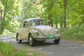 White color Volkswagen classic car from 1971 driving on a country road