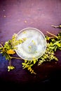 Detoxifying white ice tea in a transparent glass cup on wooden surface.