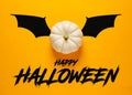 White colored pumpkin over yellow background with bat wings with the message happy Halloween Royalty Free Stock Photo