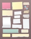 White and colorful torn, lined, and squared note, notebook paper with adhesive, sticky tape on brown background.