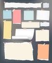 White and colorful torn, lined, and squared note, notebook paper stuck with adhesive, sticky tape on dark gray