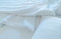 White comfort bed and soft pillow in modern bedroom. White linen blanket in hotel bedroom. Closeup detail of messy white blanket Royalty Free Stock Photo