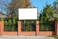 White commercial billboard with space for mockup over red brick fence