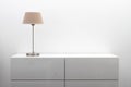 White commode with table lamp in bright minimalism interior
