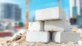Stack of white concrete blocks on a dirt pile, representing building materials and construction industry growth Royalty Free Stock Photo