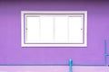The white concrete window frame background, which is sliding against a purple wall and blue PVC water pipes below. Royalty Free Stock Photo