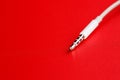 White connector AUX white cable on a red background Royalty Free Stock Photo