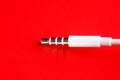 White connector AUX white cable on a red background Royalty Free Stock Photo