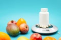 White container with medical pills on scales with fruits Royalty Free Stock Photo