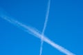 White contrails like X of two planes in clear blue sky. Jet trails on blue sky. Royalty Free Stock Photo