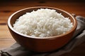 White cooked rice in a brown wooden bowl on a wooden table. Generated by artificial intelligence Royalty Free Stock Photo
