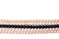 White, coral pink, black pearls on a white background with space for text. Top view, flat lay Royalty Free Stock Photo