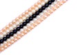 White, coral pink, black pearls on a white background with space for text. Top view, flat lay Royalty Free Stock Photo