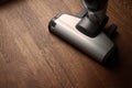 White cordless vacuum cleaner on wooden brown parquet floor Royalty Free Stock Photo