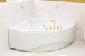 White corner bath, whirlpool. Golden faucet, faucet on the bathroom. Golden hooks on the wall Royalty Free Stock Photo