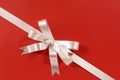 White corner diagonal gift ribbon bow on red paper background Royalty Free Stock Photo