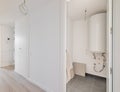 White corridor with an entrance to the boiler room with a water heater and build-in wardrobe during renovation. Concept Royalty Free Stock Photo
