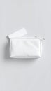 White cosmetic bag and small tissue box on a clean, minimalist gray background Royalty Free Stock Photo