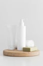 White cosmetic bottle and a tube of cream mockup with a natural soap and a towel on a white table Royalty Free Stock Photo