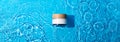 White cosmetic jar on the blue water surface. Blank label for branding mock-up. Summer water pool fresh concept. Flat lay, top