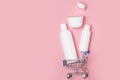 White cosmetic jars with shampoo, shower gel, hand soap lie in shopping carts. Online store for home Royalty Free Stock Photo