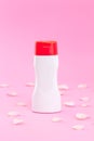 White cosmetic plastic bottle or container product for gel, lotion, cream, branding mock up on pink background with rose petal,