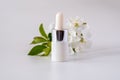 White cosmetic skincare dropper bottle packaging cherry blossoms flowers on white background