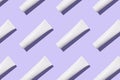 White cosmetic tube with cream on trendy purple background, pattern Royalty Free Stock Photo