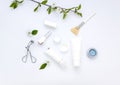 White cosmetics flat lay with flowers and leaves. Clean beauty concept