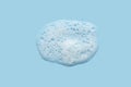 White cosmetics foam texture on blue background. Cleanser, shampoo bubbles, wash - liquid soap, shower gel, shampoo Royalty Free Stock Photo