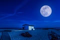 White cottage on the beach at night