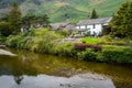 White cottage house on the picturesque green farmlands at the Lake District area in United Kingdom Royalty Free Stock Photo