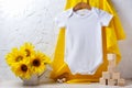 White Baby Short Sleeve Bodysuit Mockup With Sunflowers And Wooden Toys