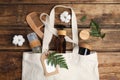 White cotton bag with eco friendly personal care products on wooden table, flat lay Royalty Free Stock Photo