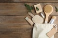 White cotton bag with eco friendly personal care products on wooden table, flat lay. Space for text Royalty Free Stock Photo