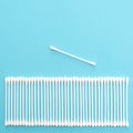 White cotton buds lie in a row on a blue background Royalty Free Stock Photo