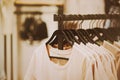 White cotton casual T-shirts hang on black hangers in a clothing store. Shopping and sale. Fashion Royalty Free Stock Photo