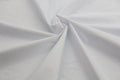 White cotton fabric of plain weave, connecting and binding seam with blue threads