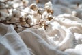 White cotton flowers on white cotton fabric background for sustainable fashion or organic products. Eco-friendly textile.