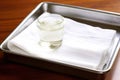 white cotton gauze on a shiny, stainless steel tray