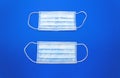 White cotton medical masks on a clasic blue background.