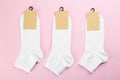 White cotton socks on light pink background, flat lay